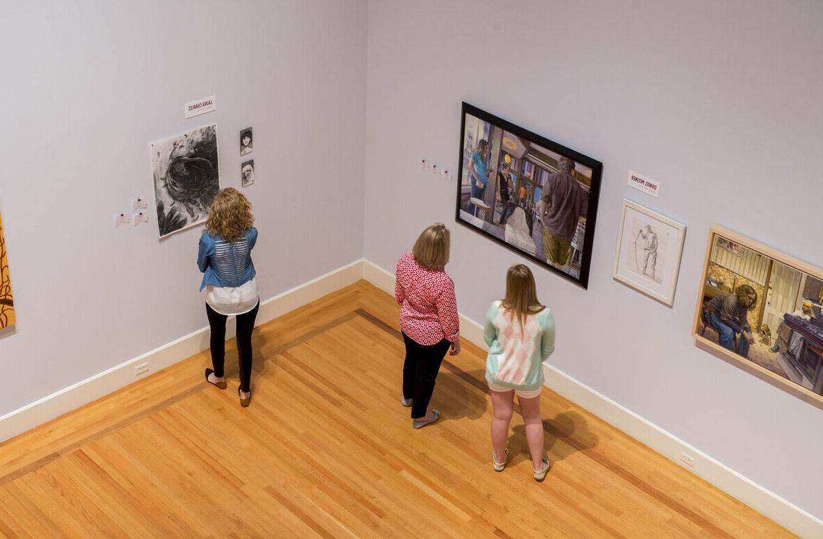 Visitors look at art on the walls of the Arnot Art Museum